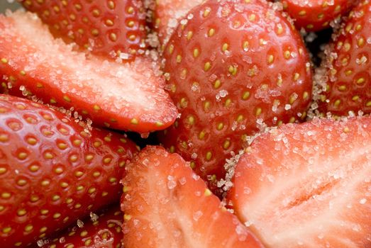 close up on some sliced strawberries covered in white sugar granules