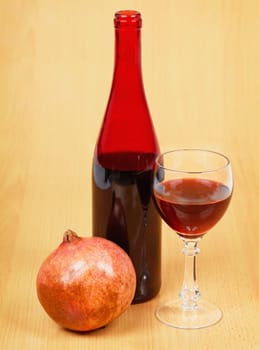 One bottle of pomegranate wine on a wooden table