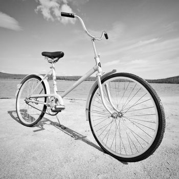 Old old-fashioned bicycle on the beach - a monochrome picture