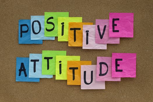 positive attitude concept - colorful sticky notes reminder on cork bulletin board 