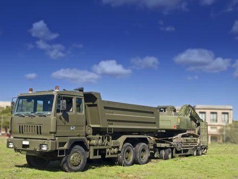 Military heavy truck and mechanical shovel in tow