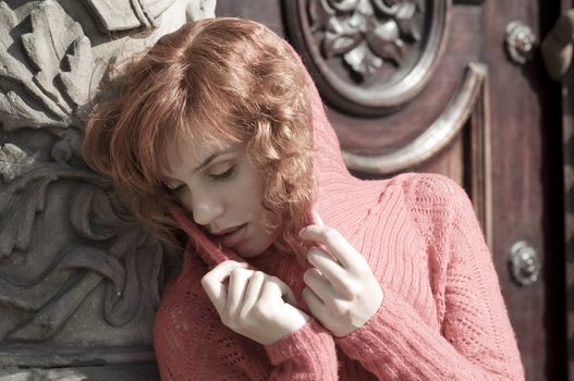 close up of a young and beautiful woman in near old door