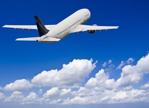 Civil aircraft flying into deep blue skies with some cloud