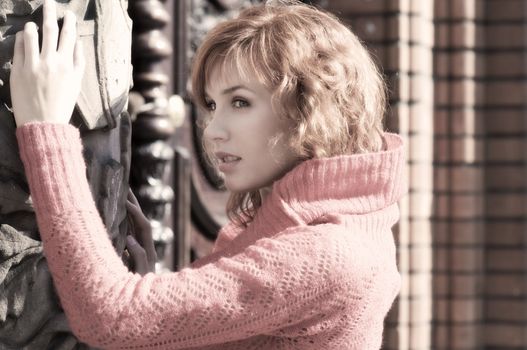 young woman in red near an old fashion door and red brick