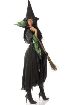 beautiful witch with hat and broom in black and green dress
