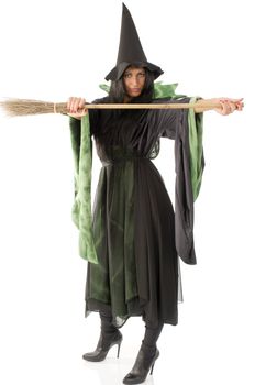 pretty witch with hat and black dress showing her broom