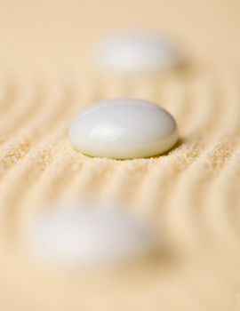 White pebbles on the surface of yellow sand closeup