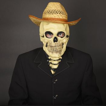 Skeleton in a straw hat on a dark background