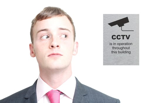A business man looking sideways at cctv