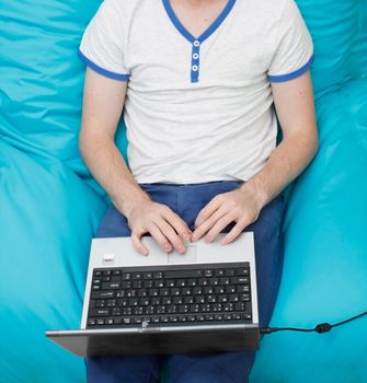 A teenager with a laptop computer on his lap