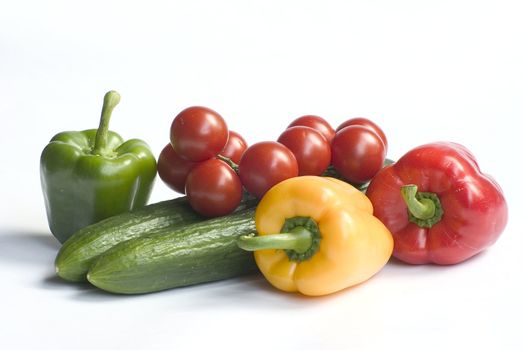 fresh cucumbers and tomatoes and peppers isolated on a white background 
