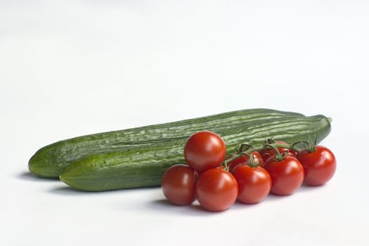 fresh green cucumbers and tomatoes isolated on a white background