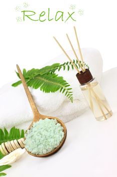 Green bath salts in a wooden spoon with essential oils and white towel. Extreme shallow DOF with selective focus on bath salts. Room for your text.