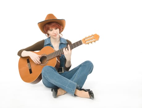 Woman sitting on a floor and playing guitar