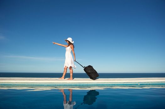 Traveler with heavy baggage walking on a swimming pool with sea view in Arraial d'Ajuda, Bahia, Brazil, Nikon D3S, Nikon AF-S 24-70, RAW shooting.