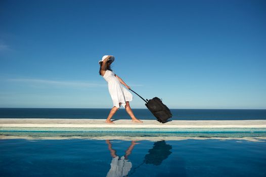 Traveler with heavy baggage walking on a swimming pool with sea view in Arraial d'Ajuda, Bahia, Brazil, Nikon D3S, Nikon AF-S 24-70, RAW shooting.