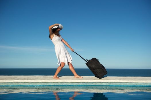 Traveler with heavy baggage walking on a swimming pool with sea view in Arraial d'Ajuda, Bahia, Brazil, Nikon D3S, Nikon AF-S 24-70, RAW shooting.