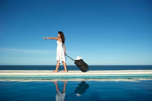 Traveler with heavy baggage walking on a swimming pool with sea view in Arraial d'Ajuda, Bahia, Brazil, Nikon D3S, Nikon AF-S 24-70, RAW shooting.