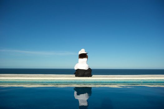 Traveler with heavy baggage walking on a swimming pool with sea view in Arraial d'Ajuda, Bahia, Brazil, Nikon D3S, Nikon AF-S 24-70, RAW shooting.