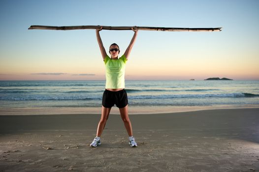 Woman doing exercises during sunset with sunglasses in Florianopolis, Santa Catarina, Brazil