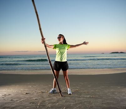 Woman doing exercises during sunset with sunglasses in Florianopolis, Santa Catarina, Brazil