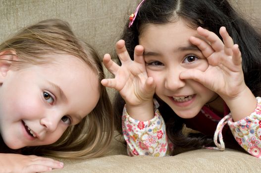 two cute little girls lying on the sofa