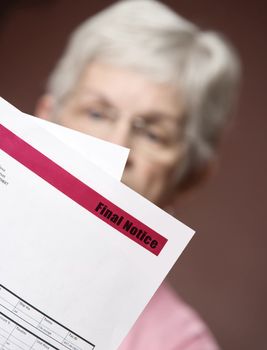 Upset senior woman with many bills and notices