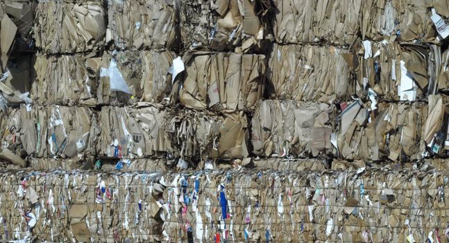 Stacks of brown cardboard boxes crushed and ready for recycling