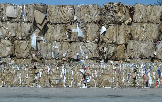 Stacks of brown cardboard boxes crushed and ready for recycling