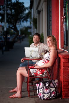 Pregnant woman sitting at a cafe with her male partner