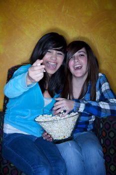 Hispanic girls with popcorn watching television