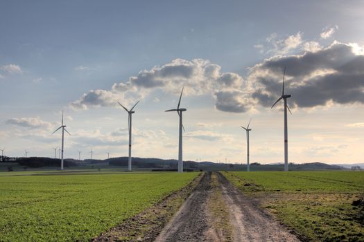 wind turbines near a dirt road in rural german landscape