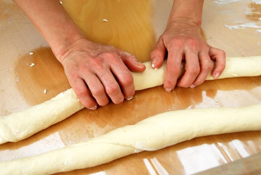 woman hands rolling out dough on table