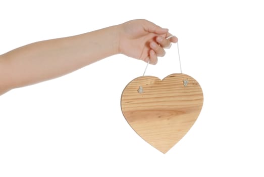 Closeup view of a child's hand holding a wooden heart, isolated against a white background.