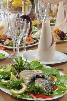 Table served in a restaurant with fish on a foreground