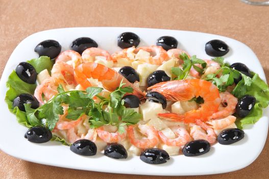 Shrimp salad in pineapple pieces, olives and parsley