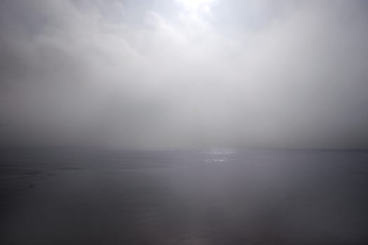 a calm sea on the west coast of ireland with a misty fog rolling in