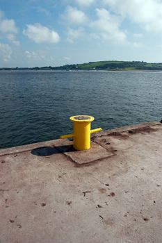 a yellow bollard on an irish quay