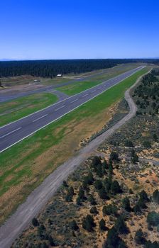 Runway from bird's eye view in helicopter with blue sky