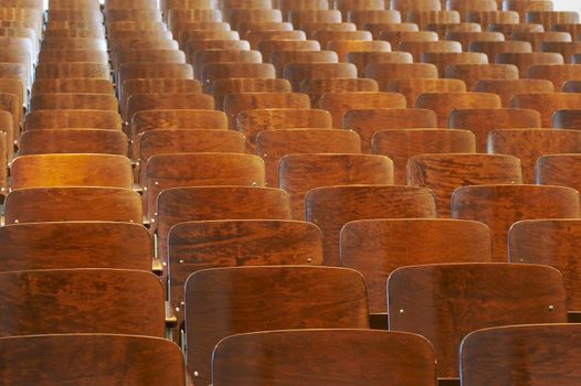 rows of wood chairs in an old auditorium