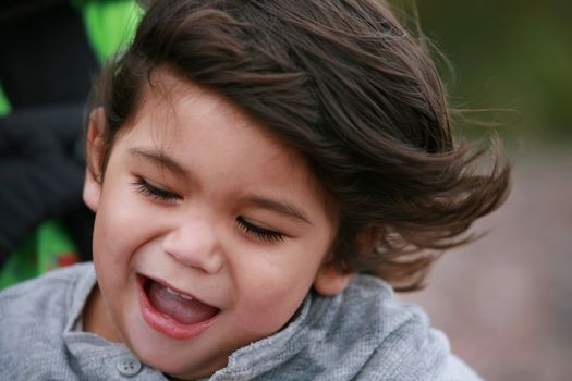 Happy little toddler boy smiling at the beach. Part Scandinavian, Thai background