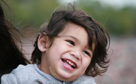 Happy little toddler boy smiling at the beach. Part Scandinavian, Thai background