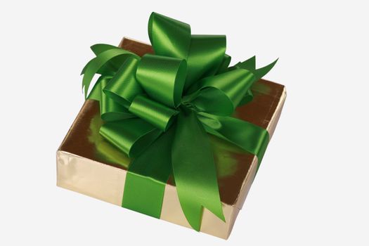 Gold present wrapped with green ribbons and bow