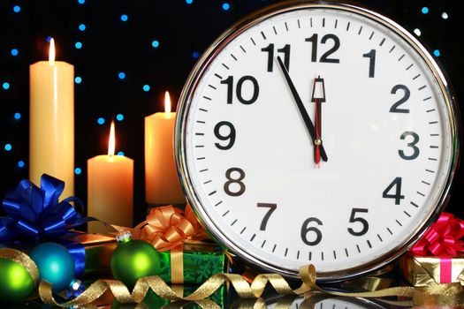 Five minutes to midnight, clock with Christmas candles and presents