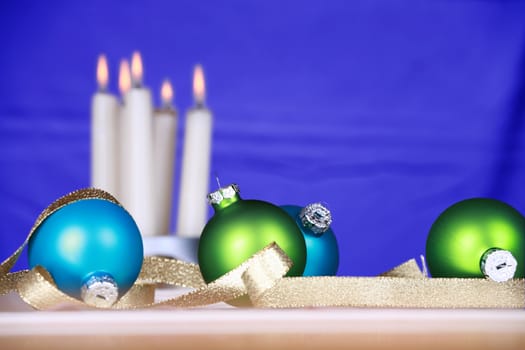 Blue and green ornaments with candles and blue background