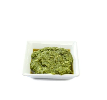 cup basil sauce on a white background