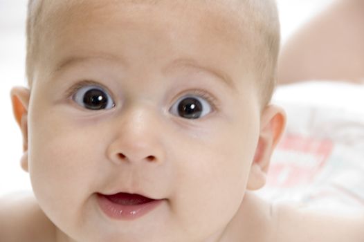 happy child lying and looking at camera on an isolated white background