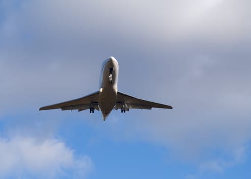 Jet airplane flying up i blue sky with clouds