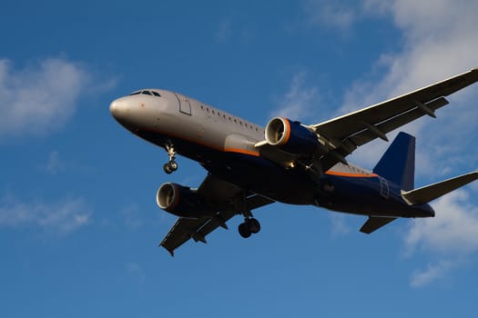 Passenger jet flying in blue sky with clouds