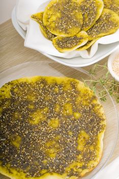 lebanese manouche or manoushe ,lebanese pizza with thyme and sesame seeds,zaatar, and extra virgin olive oil on top